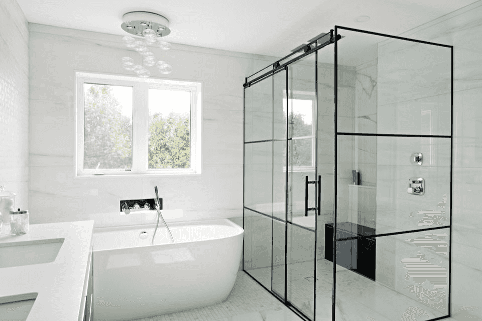 Walk-in glass shower with rainfall showerhead and tiles